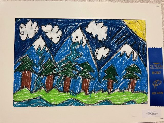 Colorful crayon drawing of mountains, trees, and a river, displayed at an art show, featuring a blue ribbon award.
