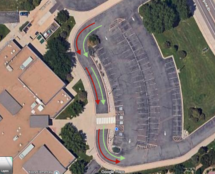 Aerial view of a parking lot with directional arrows indicating traffic flow and pedestrian pathways.